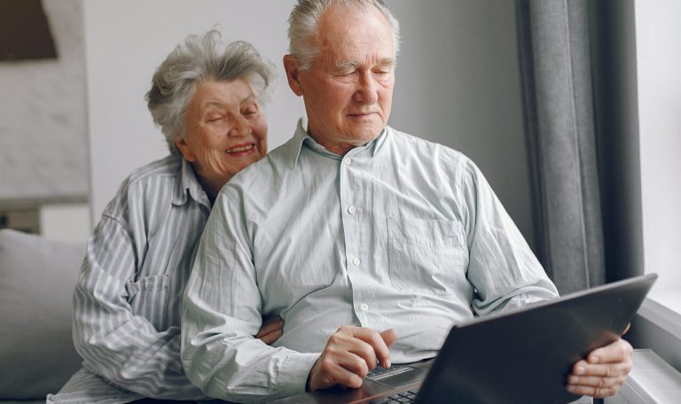 Couple de seniors accompagné à domicile utilisant un ordinateur à Chartres