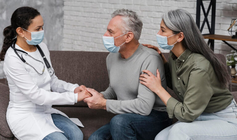 Retour d’hospitalisation : un couple est accompagné par une professionnelle de santé à domicile pour un suivi médical sécurisé